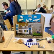Photographie d'une maquette avec des élèves en second plan.