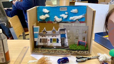 Photographie d'une maquette avec des élèves en second plan.